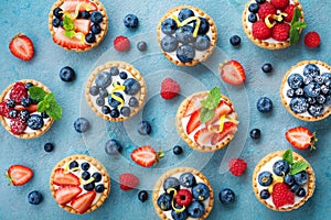 Colorful berry tartlets or cake for kitchen pattern. Pastry dessert from above.