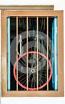 Colorful bike wheel display on a vintage window