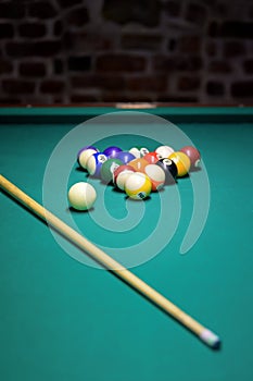 Colorful billiard balls, cue ball and cues on a green table. billiards in the club. snooker