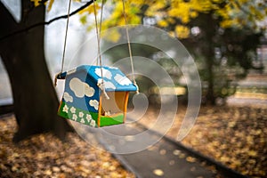 Colorful bird feeder in the autumn mist park