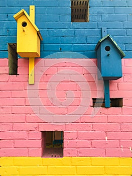 Colorful birdhouses on a multi-colored brick wall. summer. spring
