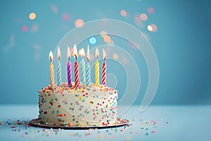 Colorful birthday cake with burning candles decorated with colorful sprinkles, ai generated