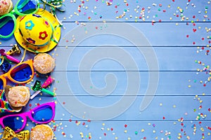 Colorful birthday or carnival border with party items on wooden background