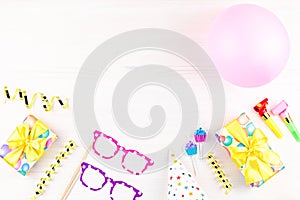 Colorful birthday party accessories on white. Wrapped gifts, confetti, balloons, party hats, decorations, copy space