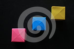 Colorful blank origami paper cubes for creative notes and any idea concept on black background.  Business plans and strategy.