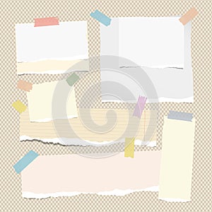 Colorful and blank white note, notebook, copybook sheets, strips stuck with sticky tape on squared brown background