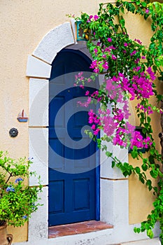 Colorful blue door of traditional greek house with yellow walls at Asos village. Assos peninsula famous and extremely