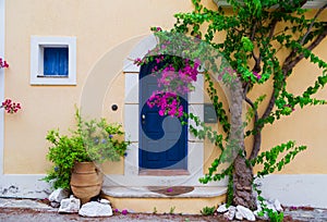 Colorful blue door of traditional greek house with yellow walls at Asos village. Assos peninsula famous and extremely