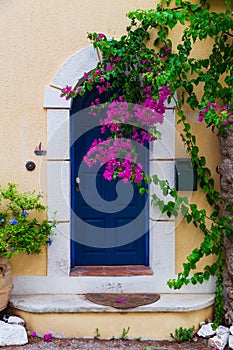 Colorful blue door of traditional greek house with yellow walls at Asos village. Assos peninsula famous and extremely