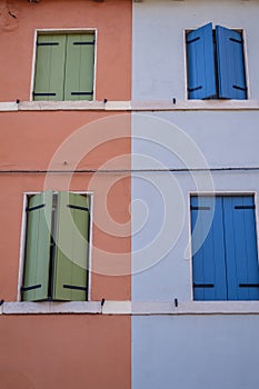 Colorful blue and green italian windows on colored houses