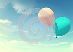 Colorful blue and pink balloons floating in summer holidays in pastel color filter, concept of summer, holidays, and joyful