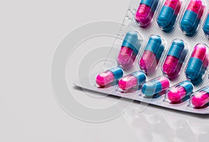 Colorful of blue, pink capsule with granule in side pills. Pills in blister pack on white background with space. Pharmaceutical