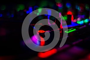 Colorful Blurred DJ Turn Table Jog Wheels with lots of turn knobs & bright cue button in dark Music Studio