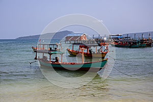 Colorful boat on seashore. Traditional wooden boats. Koh Rong island harbor landscape. Cambodia travel photo.