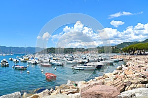 Colorful boats and seascape with old castle and blue cloudy sky with sunset in Lerici in Liguria, Italy