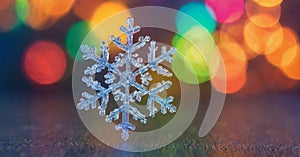 colorful, bokeh background. The snowflake exhibits intricate, symmetrical patterns and appears to be made of ice or crystal