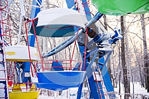 Colorful booths of ferris wheel under the snow closed