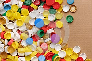 Colorful bottle caps background cardboard box. Used PET recycling plastic bottle cap plastic lids. Garbage PET waste
