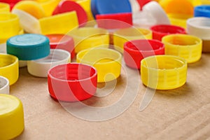 Colorful bottle caps background cardboard box. Used PET recycling plastic bottle cap plastic lids. Garbage PET waste