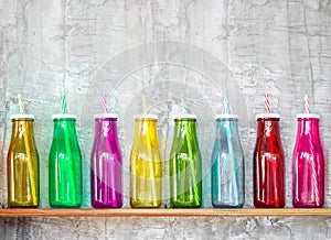 Colorful bottles on the wooden shelf