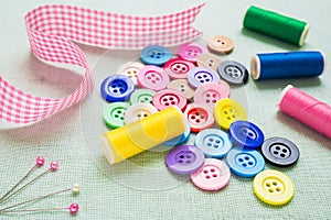 Colorful botton and thread on fabric