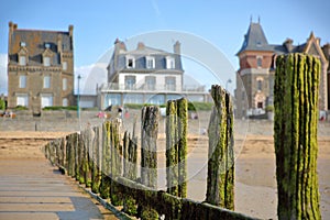 Colorful breakwaters located on Sillon beach with colorful house facades in the background, Saint Malo photo