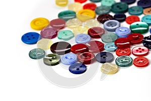 Colorful bright buttons on a white background. Old vintage buttons close-up. Copy space. Top view. Background of buttons for