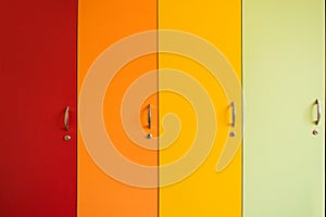 Colorful bright doors of cabinets with handles. Rainbow furniture in kindergarten or school. Bright background of yellow