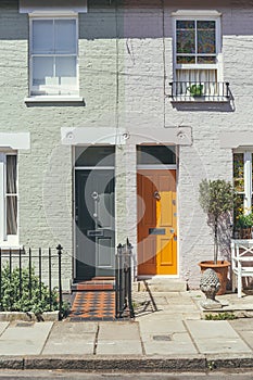 Colorful bright doors on a facade of a typical British terrace houses