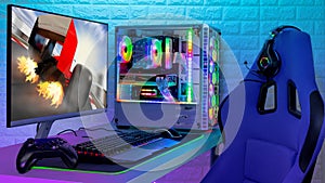 Colorful bright illuminated rgb gaming pc with keyboard mouse monitor and chair with racing  screen in front of LED light brick