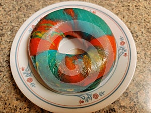colorful bright rainbow bagel with many colors on plate