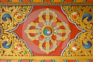 A colorful bright red yellow blue Buddhist vajra image on the wall of the temple. sacred images