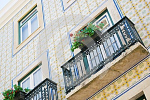 Colorful building with a green balcony decorated with flowers in Lisbon