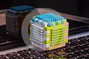 Colorful building sets on a laptop keyboard and its reflection, education concept