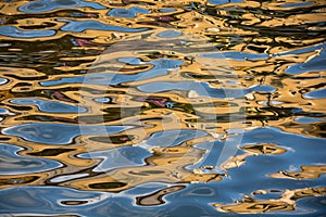 Colorful buildings reflected in the Malacca canal with water ripples making it abstract