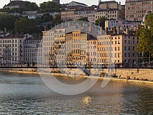 Colorful buildings washed with sun on the Rhone river bank at Ly