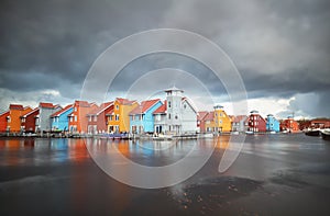 Colorful buildings on water during storm photo