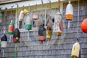 Colorful buoys on the side of a wooden cape style home