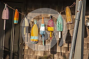 Colorful buoys on the side of a wooden cape style home