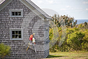 Colorful buoys on the side of a wooden cape style home