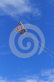 Colorful butterfly kite across a blue sky