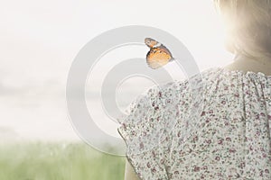 A colorful butterfly leans delicately on the shoulders of a girl photo
