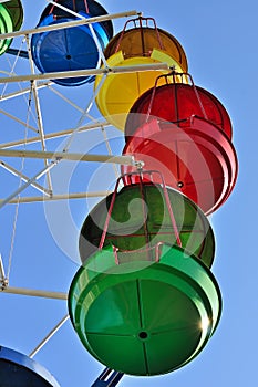 Colorful cabins of ferris wheel against the blue sky