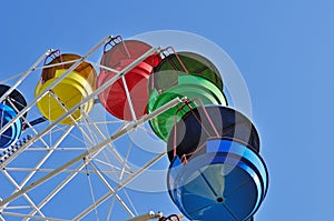 Colorful cabins of ferris wheel against the blue sky