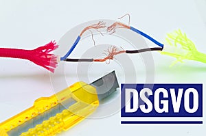 Colorful cables that were patched separately and makeshift and a craft knife with inscription in German dsgvo in English gdpr data