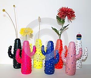 Colorful cactus shaped vases and flowers as a still life decoration