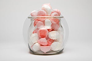 Colorful candies in jar on table background