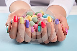 Colorful candies in womans hands.