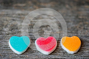 Colorful candy sweet hearts on wooden background.- Vintage filtered style.