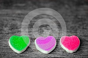 Colorful candy sweet hearts on wooden background.- Vintage filtered style.